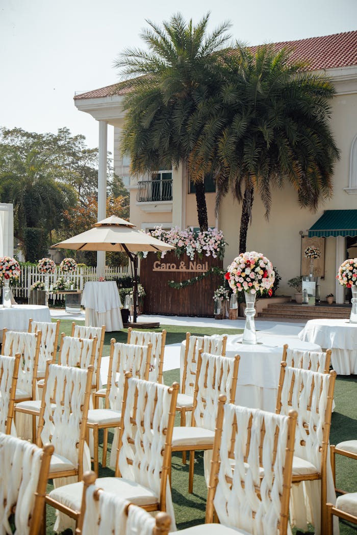 An elegant outdoor wedding setup with chairs, flowers, and decorations.